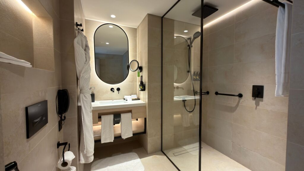 Modern hotel bathroom with walk-in shower and illuminated mirror